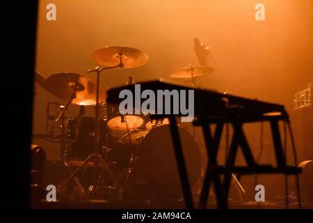 Musikinstrumente auf der Bühne mit orangefarbenem Licht Stockfoto