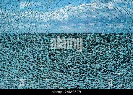 Risse Verbundglas Oberfläche gegen den blauen Himmel mit weißen Wolken unscharf im Hintergrund Stockfoto