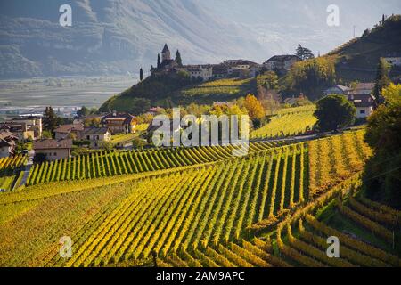 Weinberge in Herbstfarben und das Dorf St. Jakob, Tramin an der Weinstraße, Südtirol, Italien Stockfoto