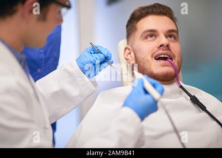 Ingwerbärtiger Kerl in einem Zahnarztbüro, der seine Zähne untersuchen ließ Stockfoto