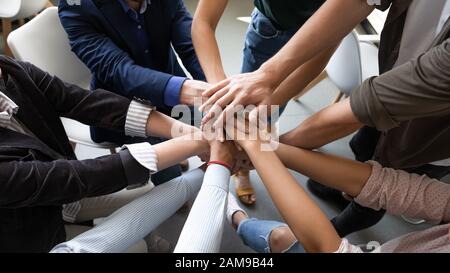 Die Hände in der Draufsicht sind als Symbol für Teambuilding zusammengestapelt Stockfoto