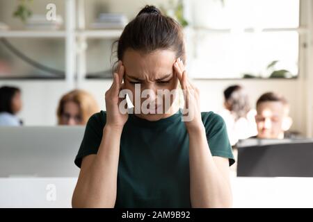 Die Büroangestellte leidet plötzlich unter Kopfschmerzen Stockfoto