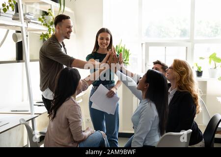 Verschiedene Kumpel, die fünf hohe Personen geben, fühlen sich vom Unternehmenserfolg motiviert Stockfoto