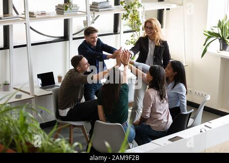 Verschiedene Büromitarbeiter, die fünf hohe Feiern zum Erfolg feiern, um Einheit zu zeigen Stockfoto