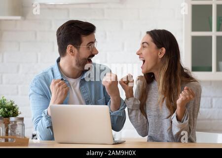 Überfreudiger junger Ehepartner, der Online-Lotto-Gewinne feiert. Stockfoto