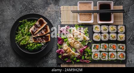 Lebensmittelbanner. Sushi rollt mit Gemüse, Knödel, Salaten. Chinesische Küche auf grauem Betongrund. Asiatische Küche. Draufsicht Stockfoto