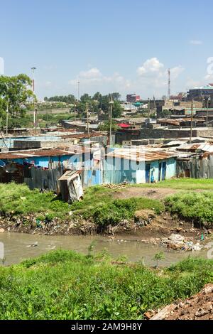 Blick auf den Fluss Nairobi, Korogocho Slum Shacks und andere Gebäude, Nairobi, Kenia Stockfoto