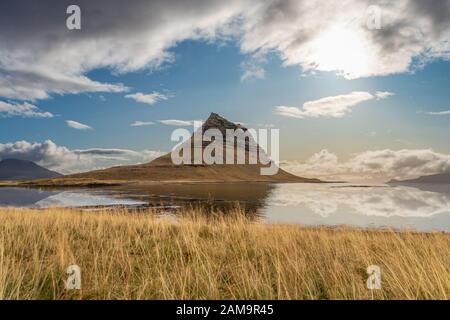 Kirkjufell reflektiert bei sonnigem Wetter im Island Snaefellsness National Park in einem ruhigen See Stockfoto