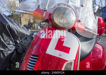 Nahaufnahme einer L-platte auf einem roten Vespa Piaggio Roller Stockfoto