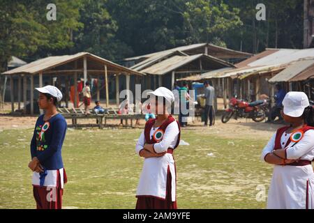 Chanda Bazar, Bongaon, West Bengal, Indien, 1. Februar, 2019: Drei Schule Mädchen in Uniform und weiße Kappe und Batch Freiwilligenarbeit Stockfoto