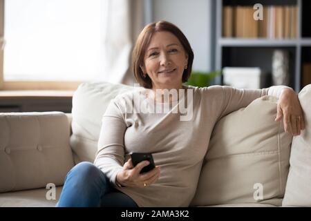 Porträt einer glücklichen Seniorin mit Handy zu Hause Stockfoto