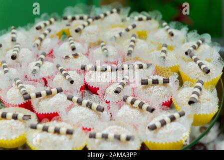 Nahaufnahme der typischen Kokosnusswürfel aus Brasilien, die von Schokoladenspänen bedeckt sind. Köstliche Süßigkeiten für die Kinderparty. Selektiver Fokus mit Unschärfe. Stockfoto