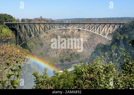 Die Victoria Falls Brücke über den Sambesi Fluss zwischen Simbabwe und Sambia, mit Regenbogen Stockfoto