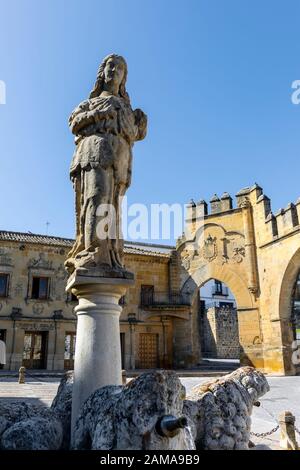 Fuente de los Leones, oder Brunnen des Löwen, in der Plaza del Populo, Baeza, Provinz Jaen, Andalusien, Spanien. Die ornamentale City Gate in der Rückseite Stockfoto