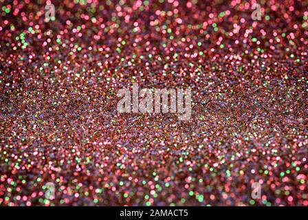 Farbenfrohes, hauptsächlich rotrosa, glitzerndes Muster mit schönem Bokeh-Effekt. Stockfoto