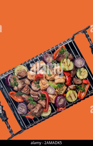 Verschiedene köstliche gegrillte Fleisch mit Gemüse über den Kohlen auf einem Grill Stockfoto