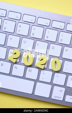 Holznummern 2020 auf der Tastatur auf gelbem Hintergrund. Draufsicht. Nahaufnahme. Stockfoto
