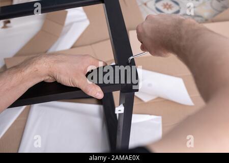 Hand verwendet das Holz der Innensechskantschrauben. Montage neuer Möbel Stockfoto