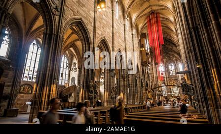 Nürnberg 2019. Innenschiff der Kathedrale St. Lorenz oder Lawrence. Wir sind an einem Sonntag und die Gläubigen geben dem Besuch von Touristen nach. August 2019 Stockfoto