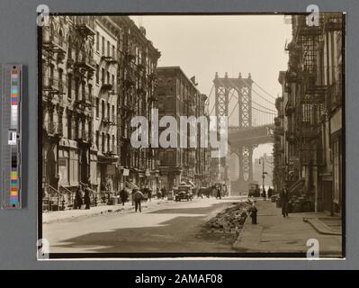 Pike und Henry Streets, Manhattan Code: U.a.5. Blick auf die Pike Street in Richtung Manhattan Bridge, Straße halb im Schatten, Schutt in Rinnen, Verkehr. Citation/Reference: CNY# 73; Pike and Henry Streets, Manhattan. Stockfoto