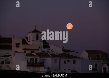 Wolf-Mond über dem Berggipfel Pueblo von Comares in Axarquia, Andalucia, Costa del Sol, Spanien Stockfoto