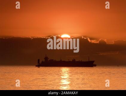 Schiffe vor Anker im Golf von Mexiko warten, bei Sonnenaufgang, vor dem Eintritt in Galveston Bay auf ihrem Weg zum Hafen von Houston, Texas, USA Stockfoto