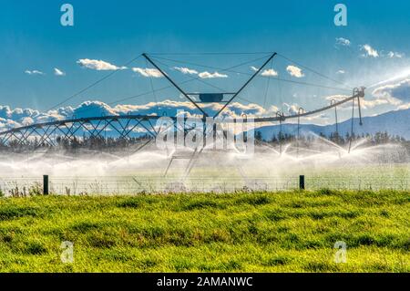 Riesige Bewässerungswassersprinkler auf Weideland in der Nähe von Ashburton, Neuseeland Stockfoto