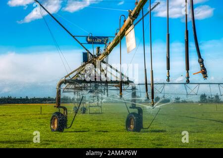 Riesige Bewässerungswassersprinkler auf Weideland in der Nähe von Ashburton, Neuseeland Stockfoto