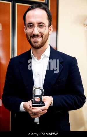 12. Januar 2020, Berlin: Igor Levit, Pianist, steht nach seiner Auszeichnung durch das Internationale Auschwitzkomitee im Maritim Hotel Berlin mit der Statue "B" als "Geschenk der Erinnerung". Levit wurde für sein Engagement gegen Antisemitismus und Rechtsextremismus ausgezeichnet. Die Statue ist dem Buchstaben "B" im Schriftzug "ARBEIT MACHT FREI" über dem Auschwitztor nachempfunden, den die Häftlinge in Auschwitz heimlich umgedreht hatten, als sie das Schild auf Befehl der SS herstellen mussten. Für die Häftlinge war diese Aktion ein Zeichen ihrer Menschenwürde und ihres Widerstands. Foto: Christoph Stockfoto