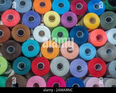 Viel Nähen von farbigem Faden. Gewinderollen. Bunte Fäden im Karton. Struktur des Nähzubehörs Stockfoto