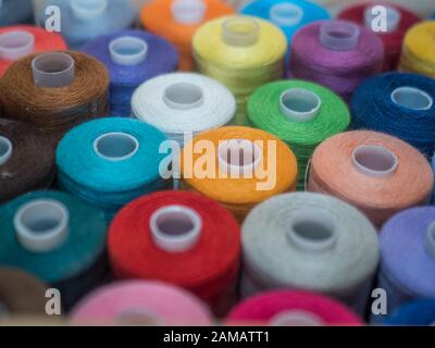 Viel Nähen von farbigem Faden. Gewinderollen. Bunte Fäden im Karton. Struktur des Nähzubehörs Stockfoto