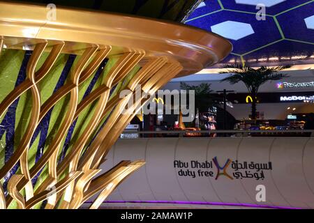 Der zentrale Bereich des Terminals 1 am Flughafen Abu Dhabi, Abu Dhabi, Vereinigte Arabische Emirate, enthält ein Schild, das seinen zollfreien Einkauf erwähnt Stockfoto