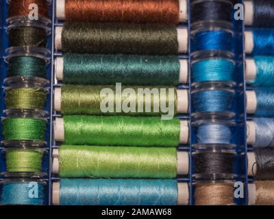 Viel Nähen von farbigem Faden. Gewinderollen. Bunte Fäden im Karton. Struktur des Nähzubehörs Stockfoto