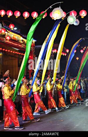 Eine Gruppe von männlichen Sundanesischen Tänzer bringen hohen Fahnen in der chinesischen Neujahrsfest Festival. Stockfoto