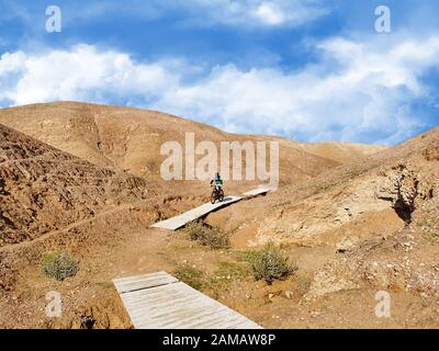 Mountainbikerfahrten auf Holzbrücken in der Wüste. Stockfoto