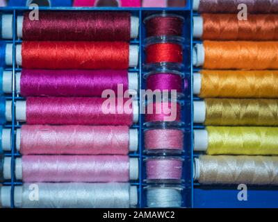 Viel Nähen von farbigem Faden. Gewinderollen. Bunte Fäden im Karton. Struktur des Nähzubehörs Stockfoto
