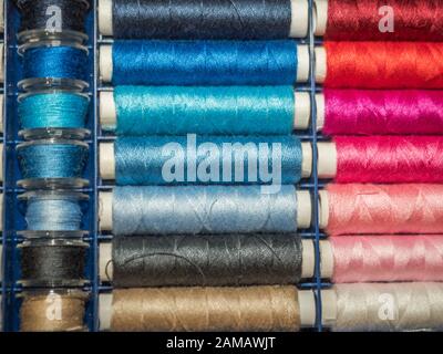 Viel Nähen von farbigem Faden. Gewinderollen. Bunte Fäden im Karton. Struktur des Nähzubehörs Stockfoto