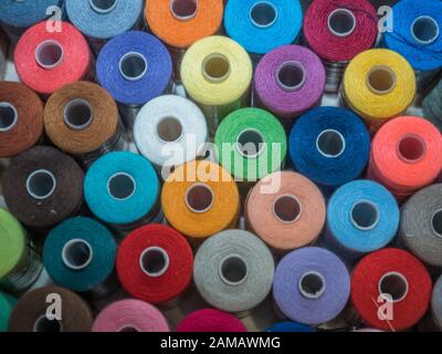 Viel Nähen von farbigem Faden. Gewinderollen. Bunte Fäden im Karton. Struktur des Nähzubehörs Stockfoto