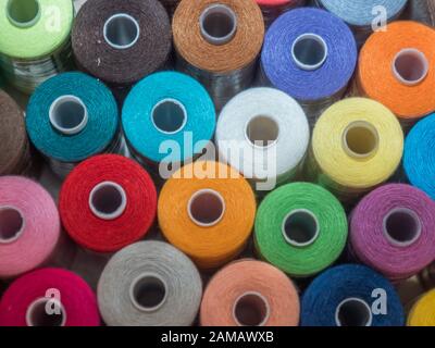 Viel Nähen von farbigem Faden. Gewinderollen. Bunte Fäden im Karton. Struktur des Nähzubehörs Stockfoto