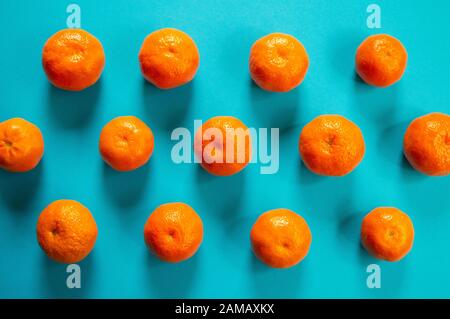 Orangefarbene Mandarinen flach lagen auf blauem Grund Stockfoto