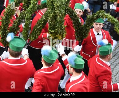 Murnau, Deutschland. Januar 2020. 16 Männer in roten Jacken und grünen Kappen tanzen den Schäfflertanz am Obermarkt. Der Zunfttanz der Murnauer Kojer - auch Schäffler genannt - ist nur alle sieben Jahre zu sehen. Die Tradition soll auf das Jahr 1859 zurückgehen. Credit: Angelika Warmuth / dpa / Alamy Live News Stockfoto