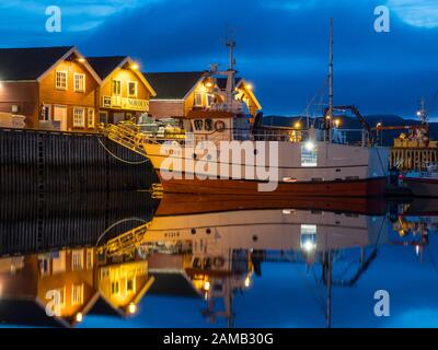 Moloen, Bodo, Norwegen - 18 August, 2019: Blick auf den Yachthafen. Fischerboote und typischen hölzernen Nordic Häuser mit Reflexion im Wasser während der Ni Stockfoto