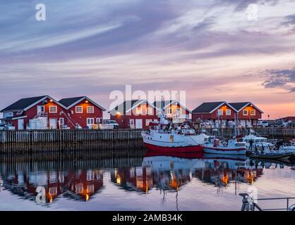 Moloen, Bodo, Norwegen - 18. August 2019: Blick auf den Jachthafen. Fischerboote und typische nordische Holzhäuser mit Spiegelung im Wasser nach Sonnenuntergang Stockfoto