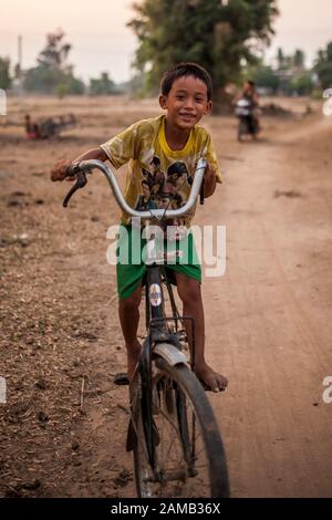 Don DET, LAOS - 5. APRIL 2013: Ein unidentifizierter Junge fährt mit dem Fahrrad durch das Dorf Don Det, Laos. Stockfoto