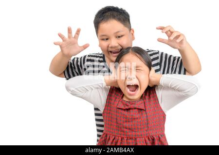 Wütender älterer Bruder attestiert seine Schwester isoliert auf weißem Hintergrund, verspieltes Konzept Stockfoto