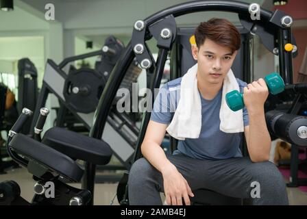 Stattliche asiatischer Mann Hanteln im Kraftsport Fitness - Sport und Lifestyle Konzept Stockfoto