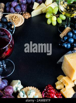 Wein und Snacks in Form einer Grenze auf schwarzem Grund Stockfoto