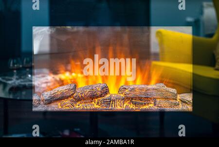 Funktionierendes Elektrokamin. Nachahmung von Feuer und brennenden Holzstämmen. Nahaufnahme. Stockfoto