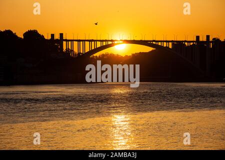 Wunderschöner oranger Sonnenuntergang über dem Fluss Duoro in Porto City Stockfoto