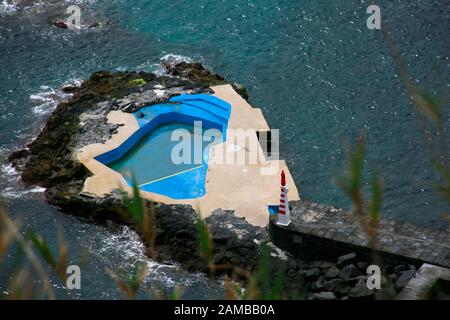 Blick vom Aussichtspunkt Miradouro do Pisao auf das Meerwasserschwimmbad und den Leuchtturm von Caloura, Agua de Pau, Sao Miguel, Azoren, Portugal Stockfoto